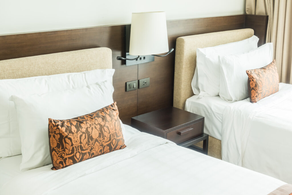 White pillow on bed decoration in bedroom interior with table light lamp